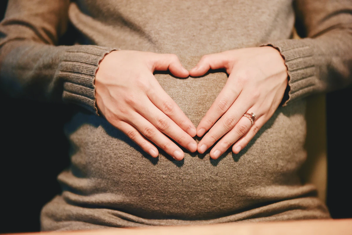 Pregnant woman reviewing health insurance documents while studying